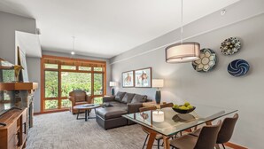 Una sala de estar moderna con una mesa de comedor de vidrio, sofás de cuero y una chimenea.