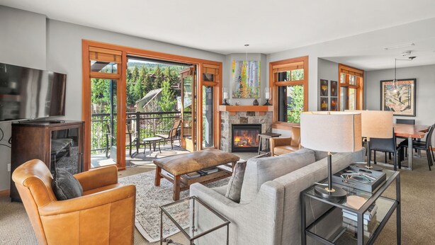 A spacious living room with a fireplace, comfortable seating, and large windows offering a view of the outdoors. - Gondola Grove | Capitol Peak Lodge #3310 | 2B/2B (Snowmass Village)