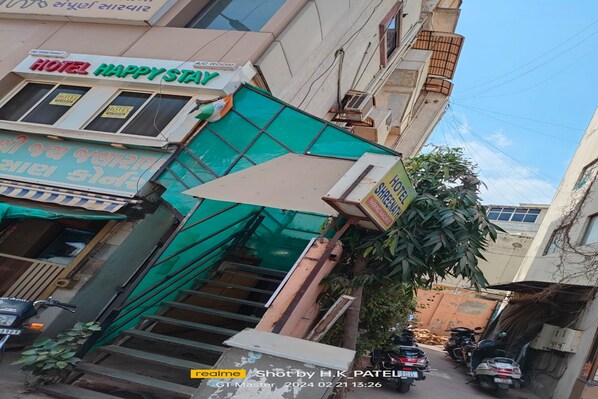 A hotel named "HOTEL HAPPY STAY" with a signboard and a green awning. - Hotel Happy Stay (Ahmedabad)
