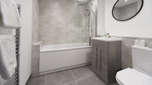 Ein modernes Badezimmer mit Badewanne, Dusche, Toilette und Waschtisch.