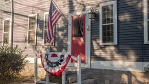 A house with a red door, a flag, and a decorative banner.
