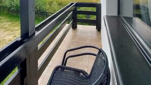 A balcony with a view of a field and mountains.