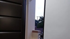 A narrow hallway with a dark door on the left and a white wall on the right. - Cozy, Safe, and Secure Two-Bedroom Apartment Unit (San Carlos City)