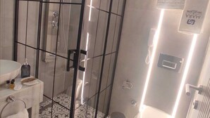 Une salle de bain moderne avec une douche à parois de verre, des toilettes et un lavabo.
