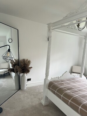 A bedroom with a four-poster bed, a large mirror, and a vase with dried flowers. - The Hidden Cottage Near Manchester Airport (Manchester)