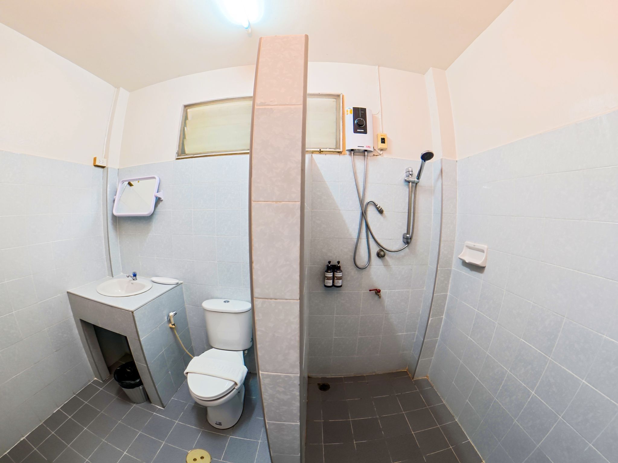 A compact bathroom with a toilet, sink, and shower.