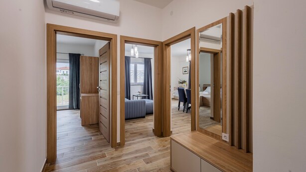 Un apartamento moderno con piso de madera, comedor, dormitorio y baño.