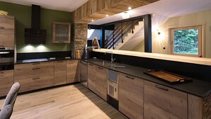 Een moderne keuken met houten kastjes, een zwart aanrecht en een ingebouwde kookplaat.