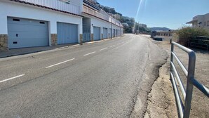 A street with a row of buildings, each with a garage door.