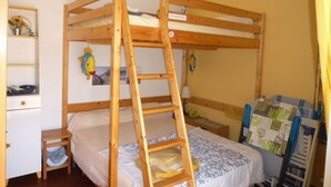 A bunk bed room with a wooden ladder, a small bedside table, and a shelf with a picture. - Charming 2-Bed Apartment, A/C, Sleeps 4, Near Beach, Parking Included (Port Leucate)