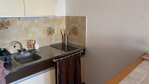 A compact kitchen with a sink, a stovetop, and a small countertop. - Studio with Pool, 4 Pers., Port Leucate, Parking (Port Leucate)