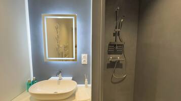 Luxe maisonnette | Badkamer | Een douche, een haardroger, handdoeken, zeep