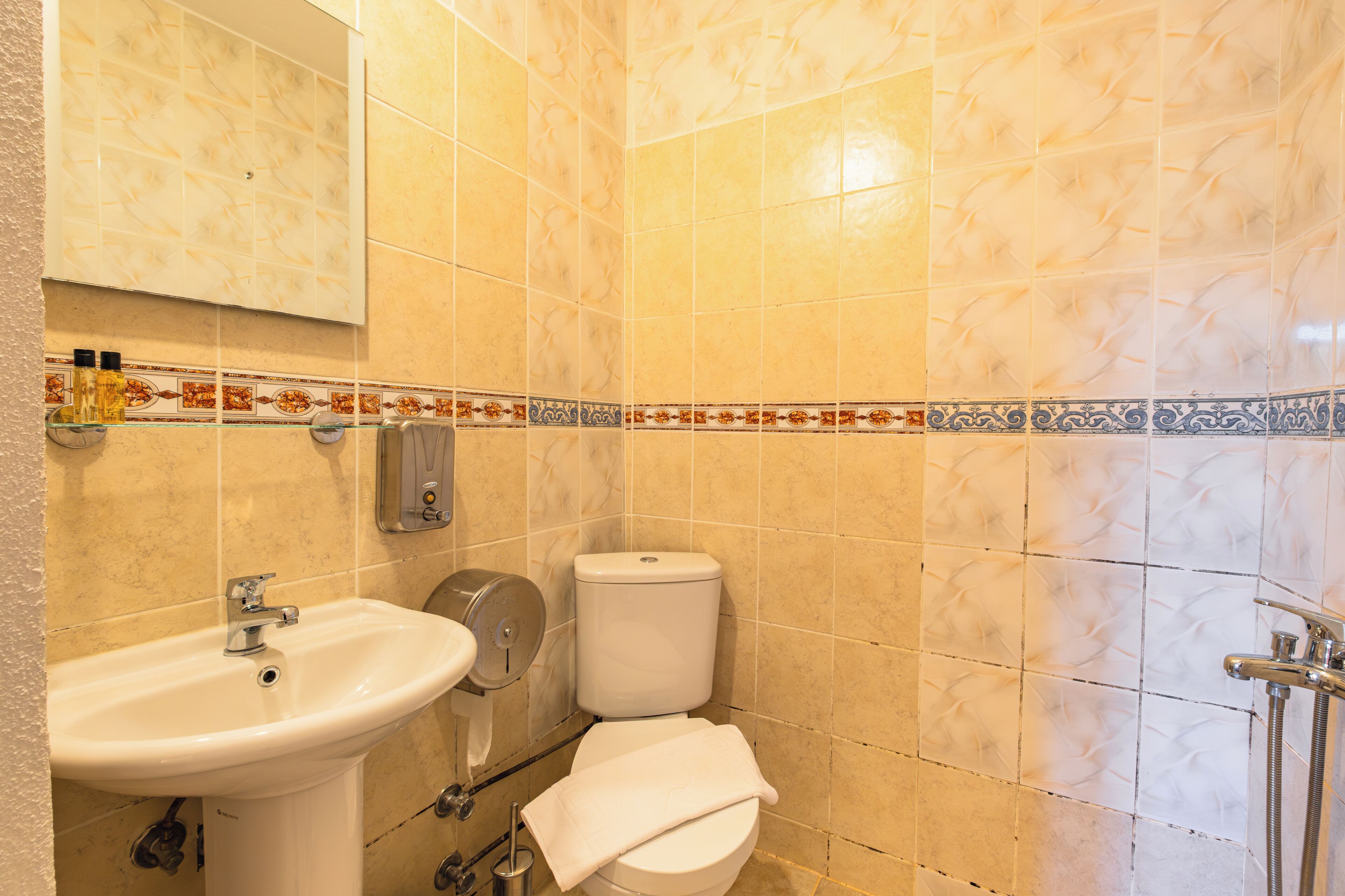 Un baño con lavamanos, inodoro y ducha.