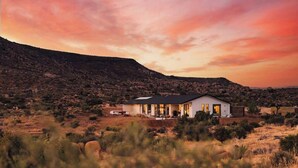 Una casa moderna con techo plano, ventanas amplias y un patio.