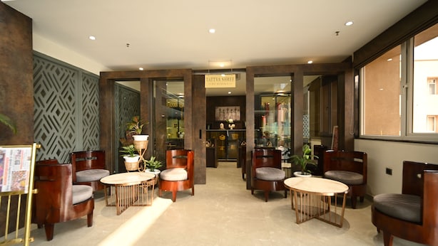 A modern interior with wooden furniture, a reception desk, and a sign reading "TATTVA SHREE". - Rohika AAU-IGH (Guwahati)