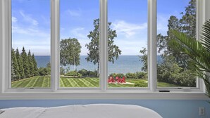 Une chambre avec une grande fenêtre donnant sur un terrain de golf et la mer.
