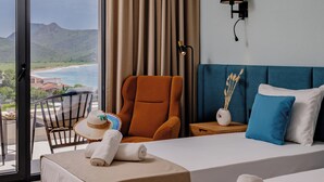 A hotel room with a large window, a bed, a chair, and a bedside table. - Hotel Aquilo (Petrovac)