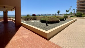 A rooftop terrace with a view of the sea, featuring a landscaped garden with gravel and plants, and a tiled floor. - Bright and fully equipped in a front line development (La Manga del Mar Menor)