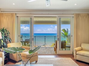 A spacious living room with a large sliding glass door leading to a balcony with a view of the ocean. - Panoramic Oceanview Penthouse • Turtle Bay Luxury Resort/Beach/Pool/Hot tub (Kahuku)