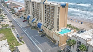 Un hôtel de grande hauteur doté de nombreux balcons, d’une piscine et offrant une vue sur la plage.