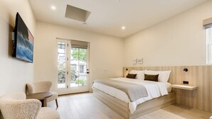 Een moderne slaapkamer met een groot bed, een klein tafeltje en een stoel.