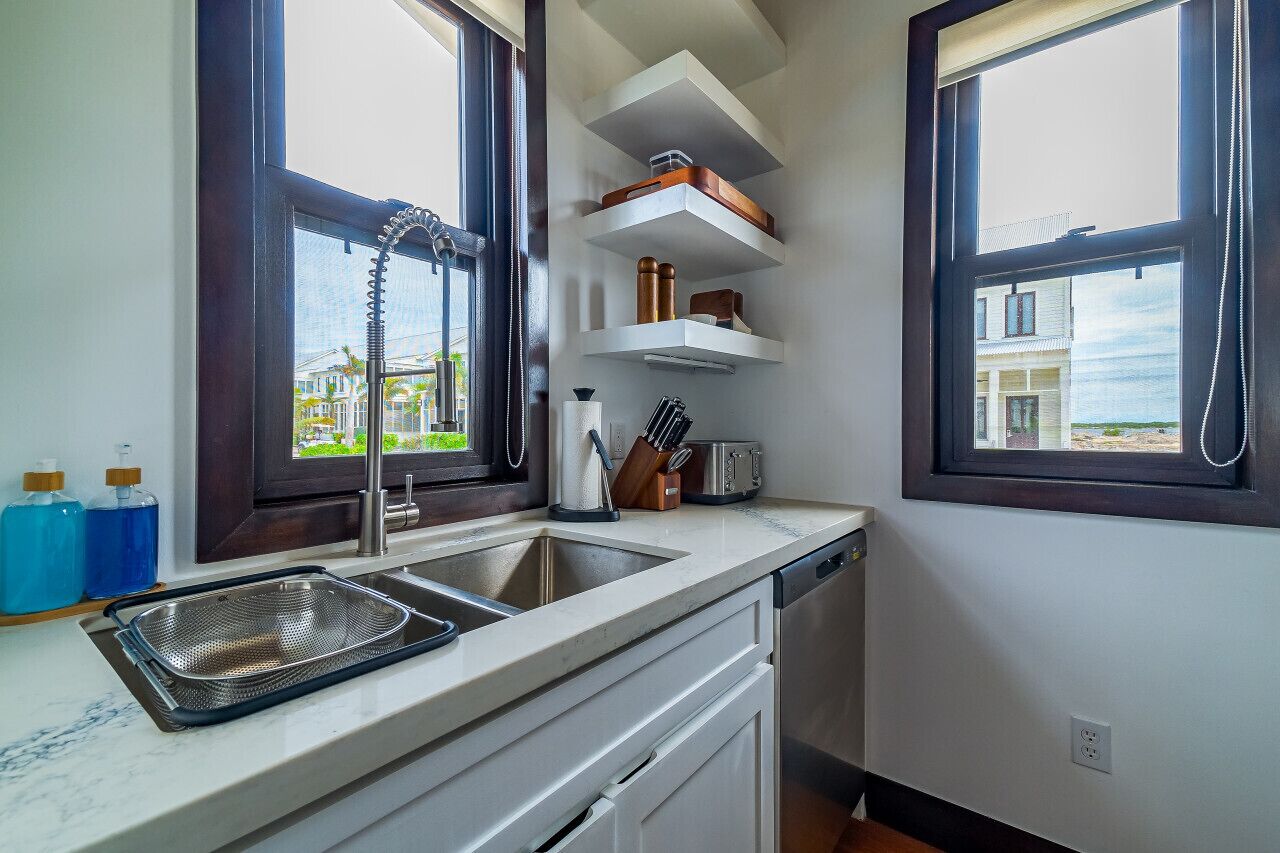 A kitchen with a sink, countertop, and window.