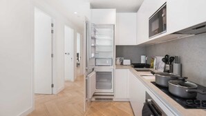 Une cuisine moderne avec des armoires blanches, un four encastré, un four à micro-ondes et une cuisinière.