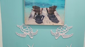 Eine Wand mit einem Gemälde einer Strandansicht und dekorativen Meereslebewesen.