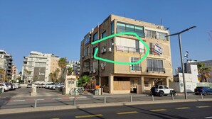 Een meerlaags gebouw met een bord waarop staat dat het een appartementenhotel is.
