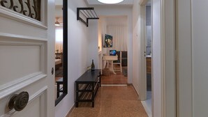 A hallway with a dining table, a bottle of wine, and a laptop. - Modern Living in Kolonaki (Athens)