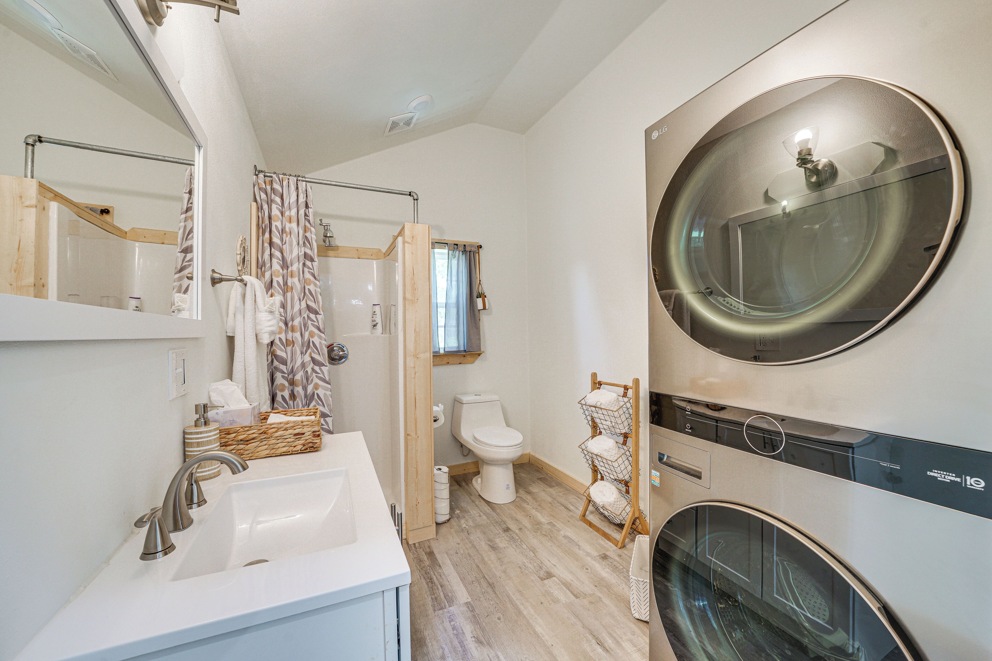 Un baño moderno con lavamanos, inodoro y lavadora integrada.