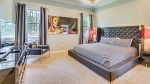Een moderne slaapkamer met een groot bed, een bureau en een stoel.