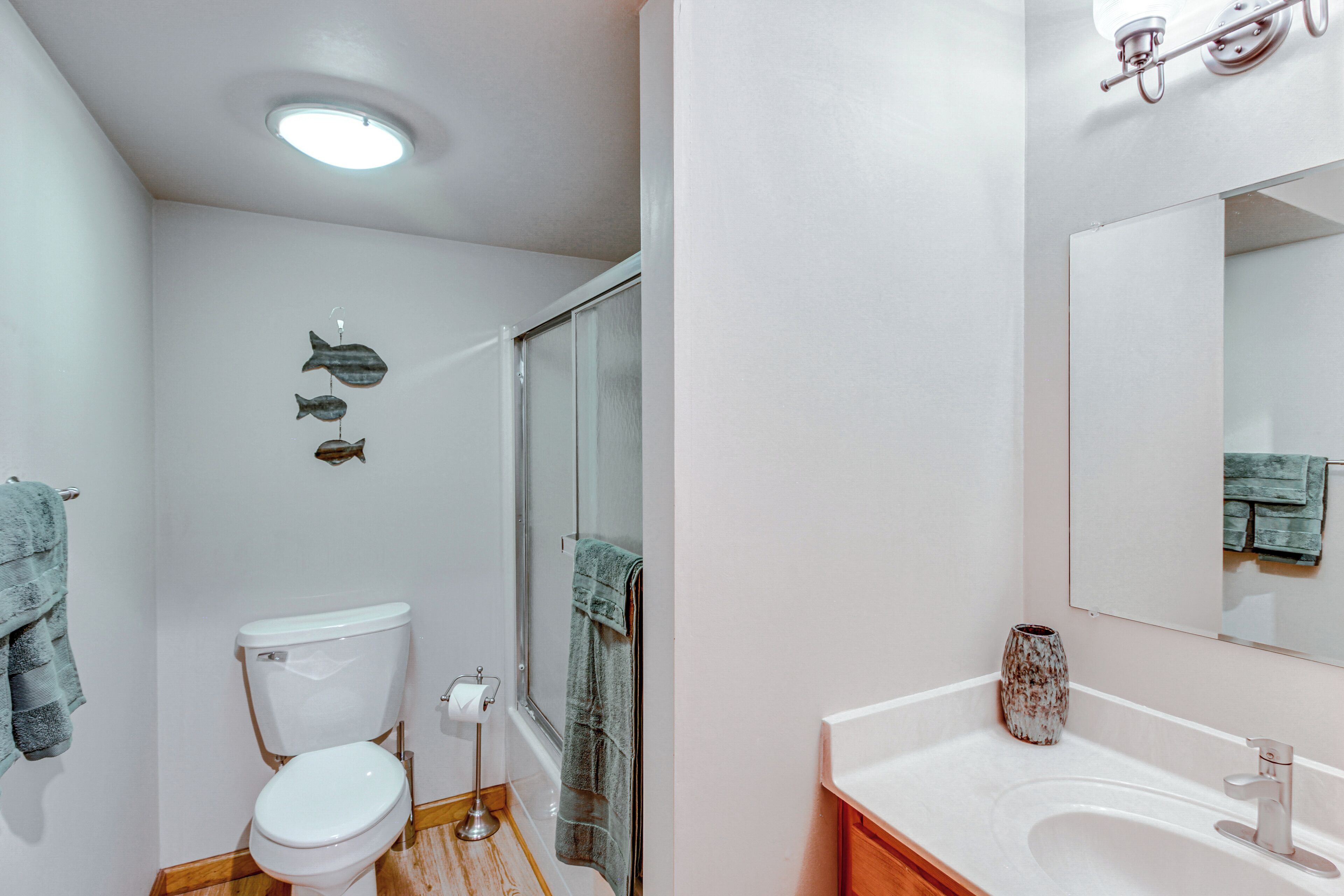 A bathroom with a toilet, sink, and shower.