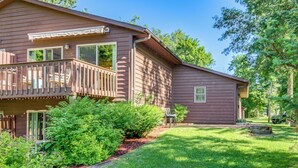 A two-story house with a balcony, surrounded by lush greenery and a well-maintained lawn. - Beach & Lake Access: Brainerd Townhome (Brainerd)