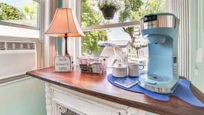 A kitchen counter with a coffee maker, a lamp, and a basket of coffee essentials. - Private Dock & Fire Pit: Houghton Lake Home! (Houghton Lake)