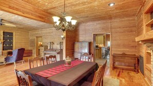 A wooden interior with a dining table, chairs, a chandelier, and a fireplace. - Private Walterboro Estate w/ Deck + Fire Pit! (Walterboro)