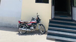 A building with a signboard in a local language, a motorcycle parked in front, and a staircase leading to the entrance. - Hotel Padmawati By GRB Stays (Abu Road)