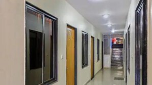 A long, narrow hallway with doors on both sides, leading to individual rooms. - Hotel Padmawati By GRB Stays (Abu Road)