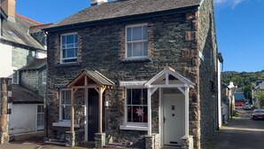 A stone building with a gabled entrance and a small porch.