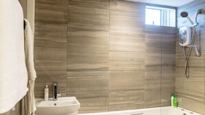 A modern bathroom with a bathtub, a shower, and a sink. - 2 Bedrooms-4 Guests-babycot-wifi-freeparking (London)