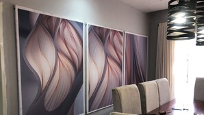 Un comedor con una mesa y sillas, una lámpara fijada a la pared y un enchufe.
