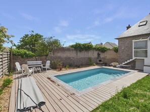A backyard with a swimming pool, wooden deck, and outdoor seating. - Unique house for 6 adults and 2 children (Erquy)