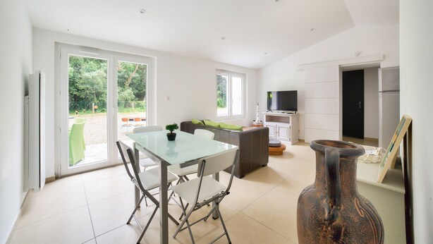 A modern kitchen with a dining area, large windows, and a TV. - 850 from de beach, new house for 6 in the wood (Longeville-sur-Mer)