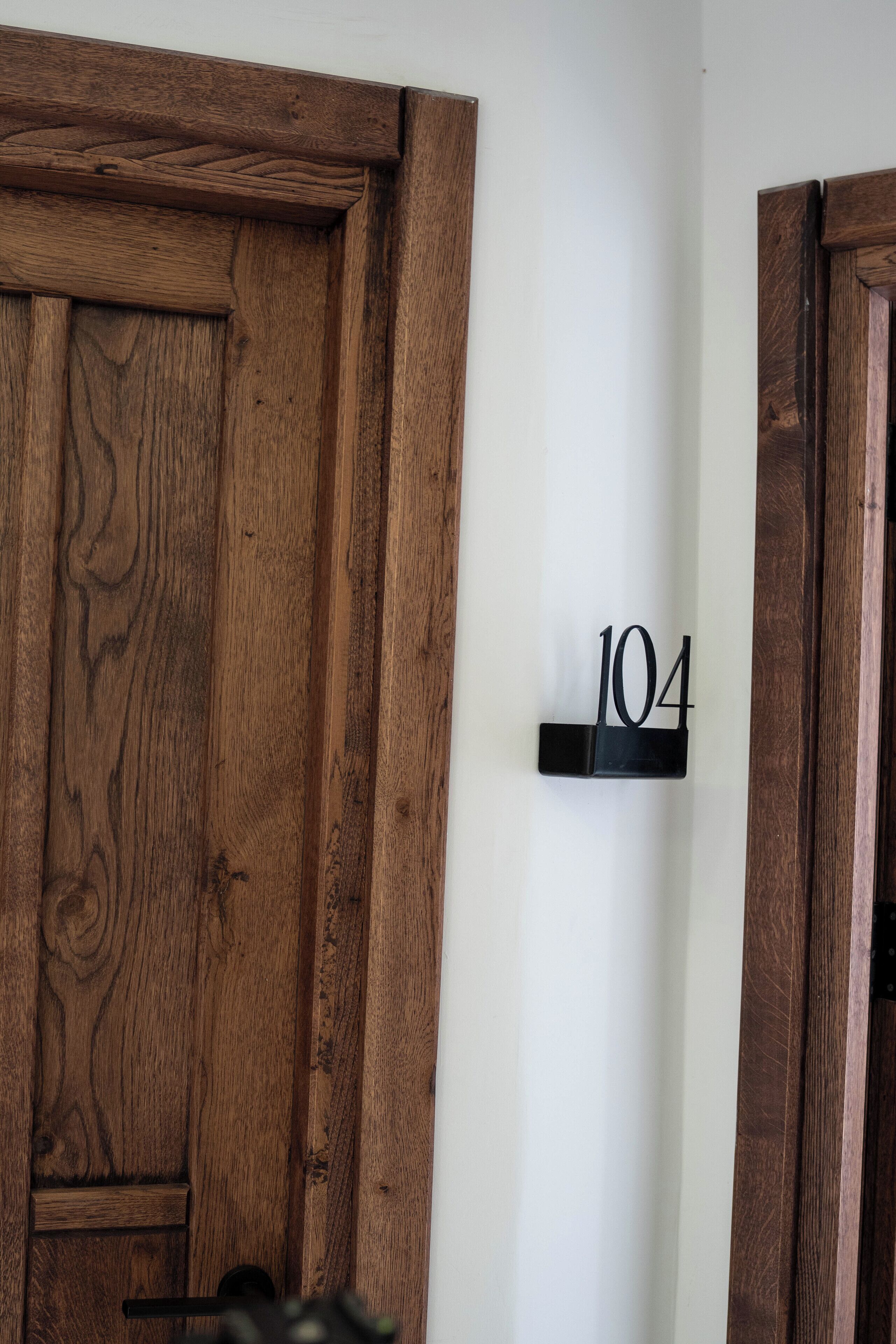 A wooden door with a number plaque indicating room 104.
