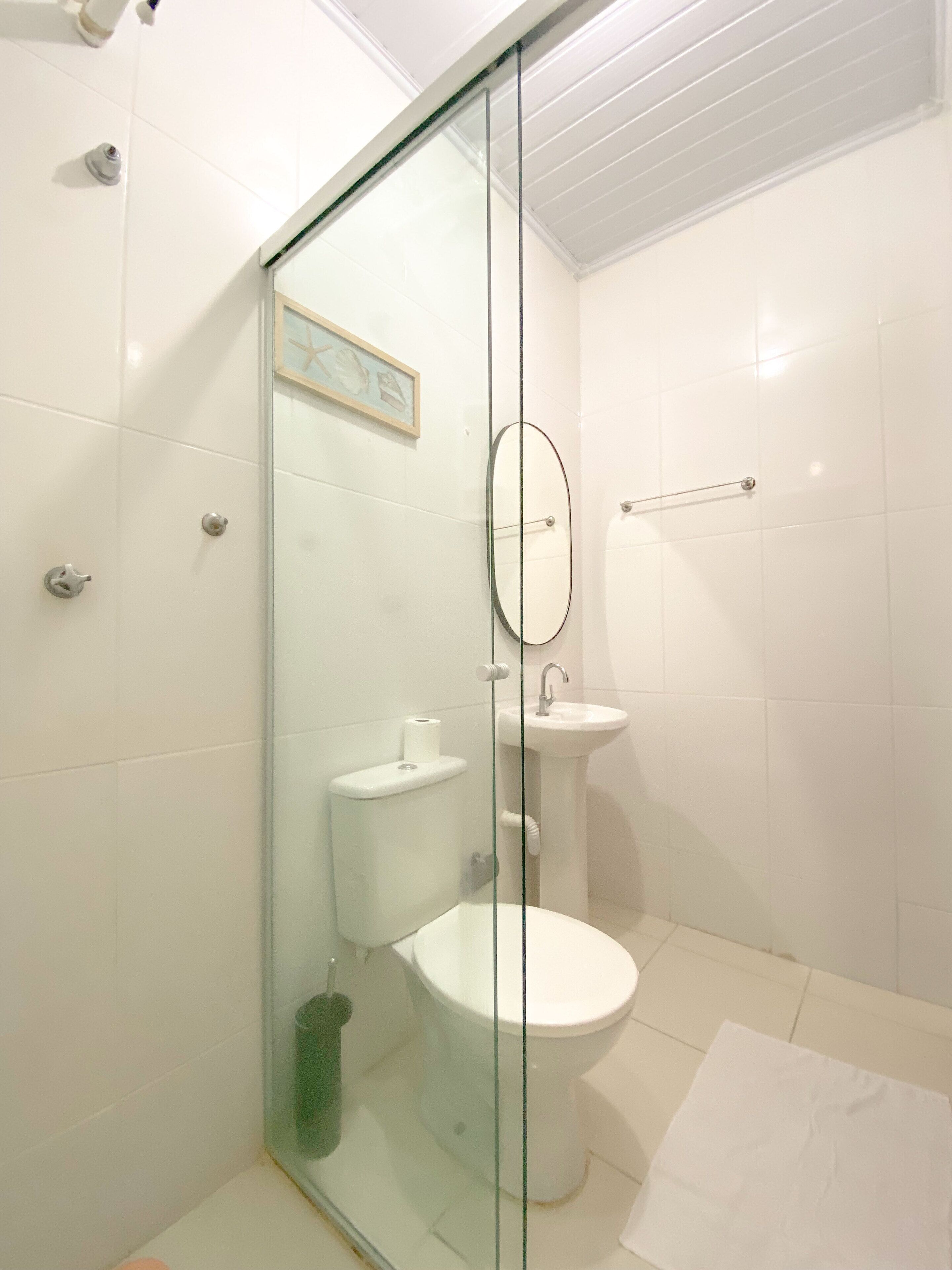 A modern bathroom with a glass shower enclosure, a toilet, and a sink.