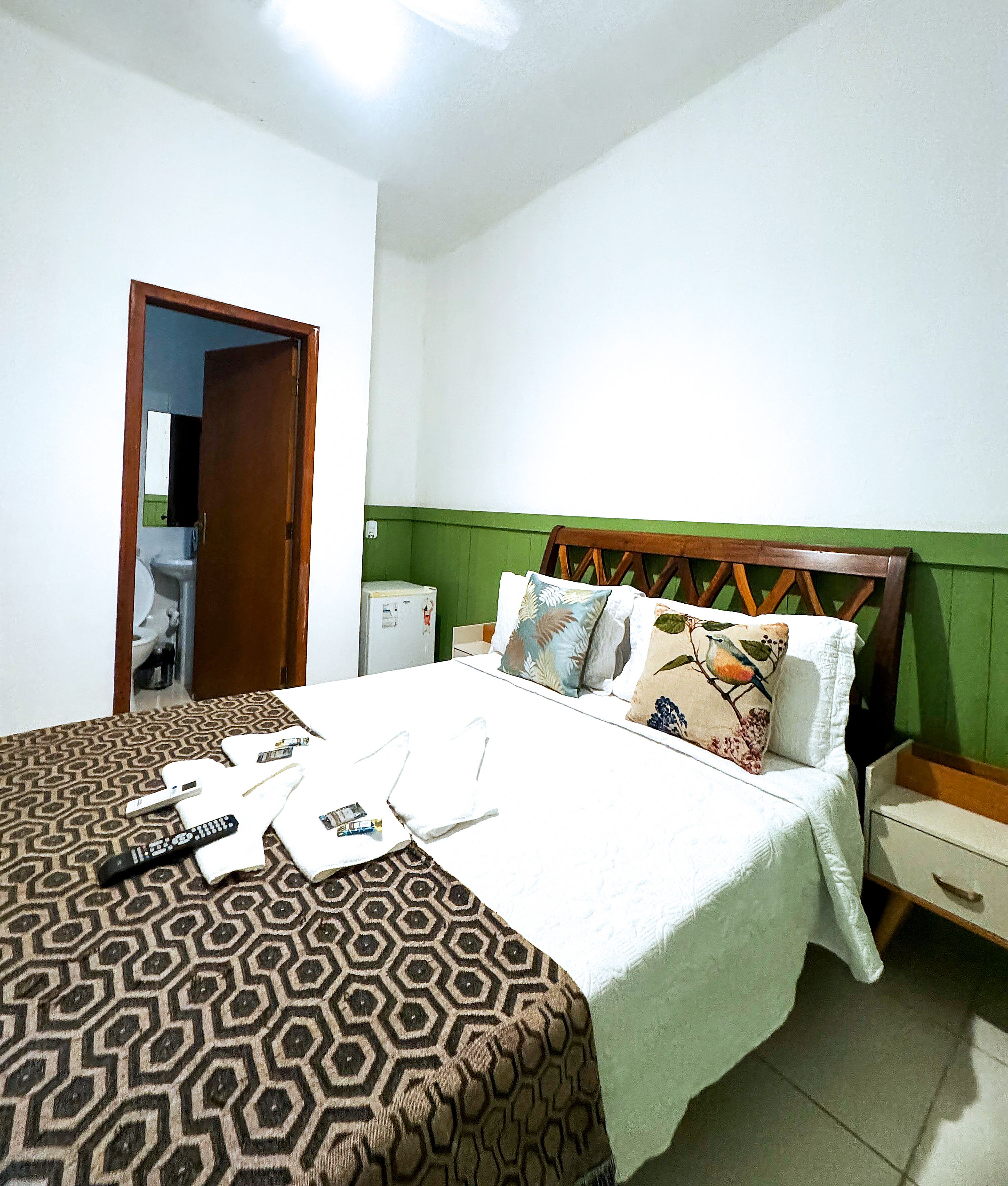 A bedroom with a bed, bedside table, and a wardrobe.