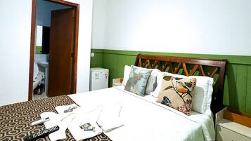 A bedroom with a bed, bedside table, and a wardrobe.