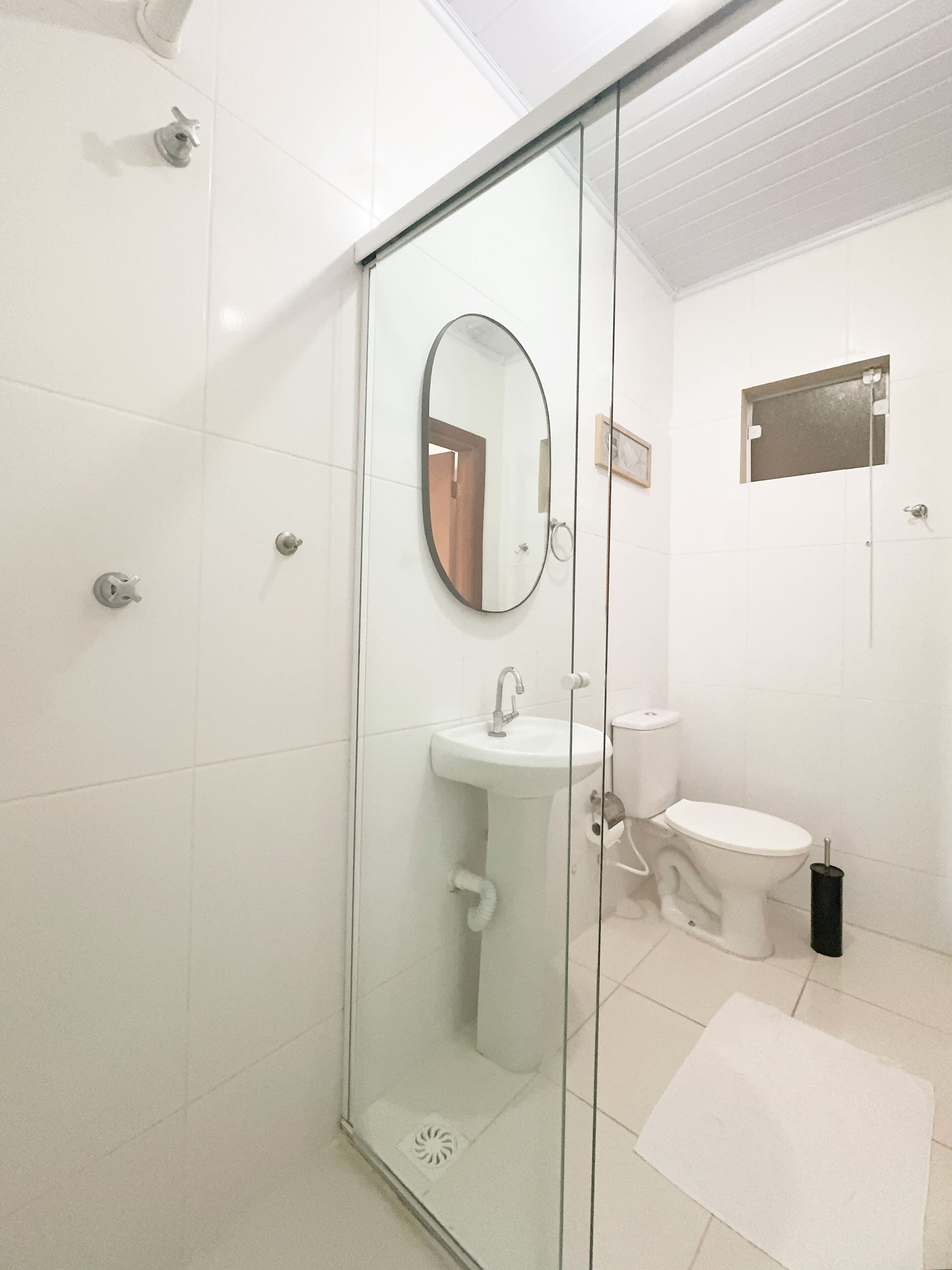 A modern bathroom with a glass-enclosed shower, a sink, and a toilet.