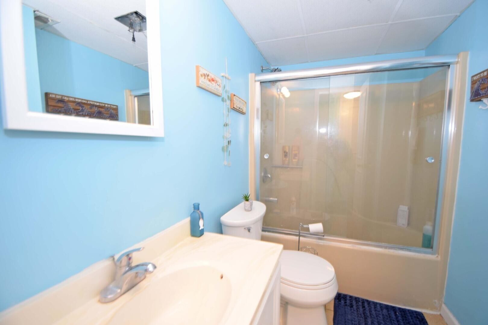 A bathroom with a sink, toilet, and glass-enclosed shower.