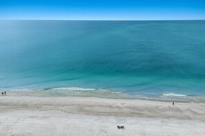 Ein Strand mit klarem, blauem Wasser und einem sandigen Ufer.